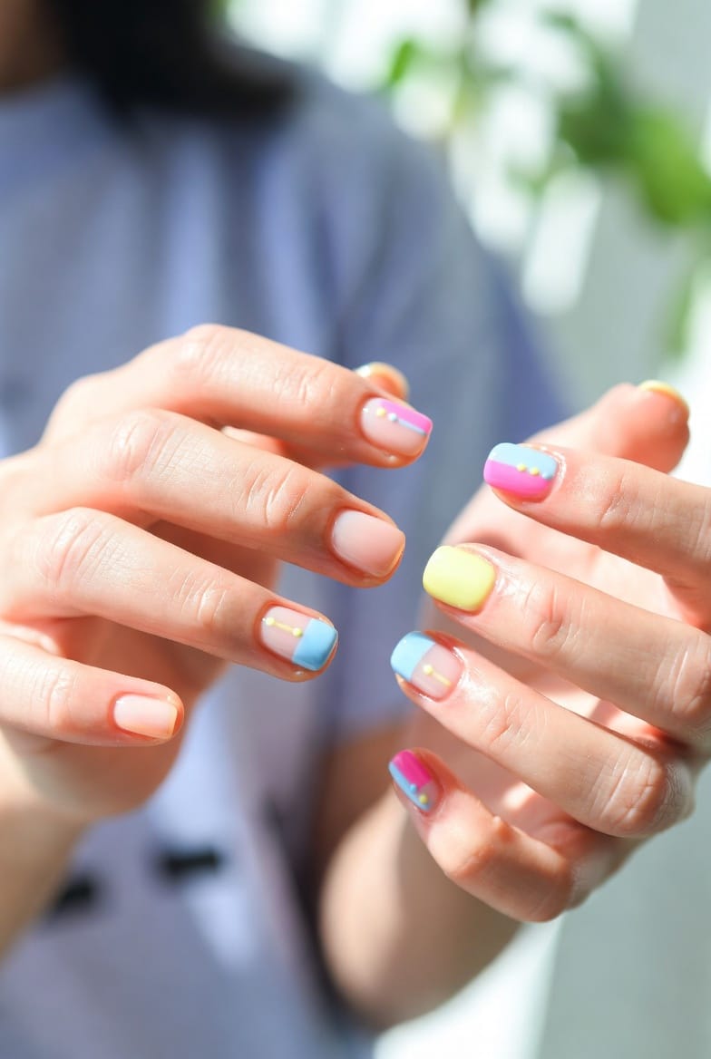 “Summer short nail designs with bright colors and cheerful accents on well-groomed nails in natural lighting.”