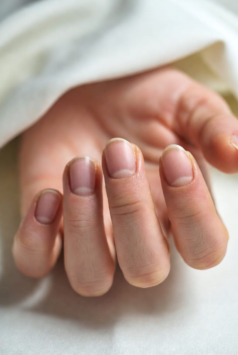 “Natural healthy fingernails with smooth cuticles and a soft shine, representing strong and beautiful nail care results.”